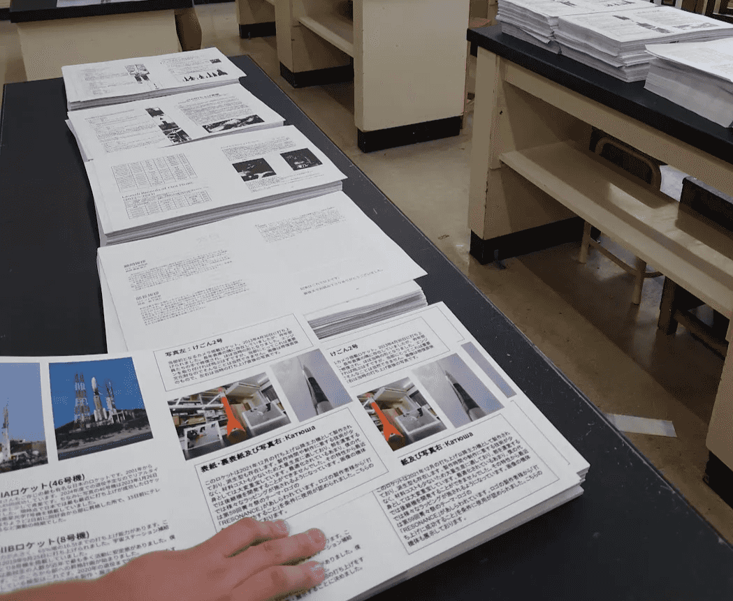 $↑部誌の製本作業の様子
