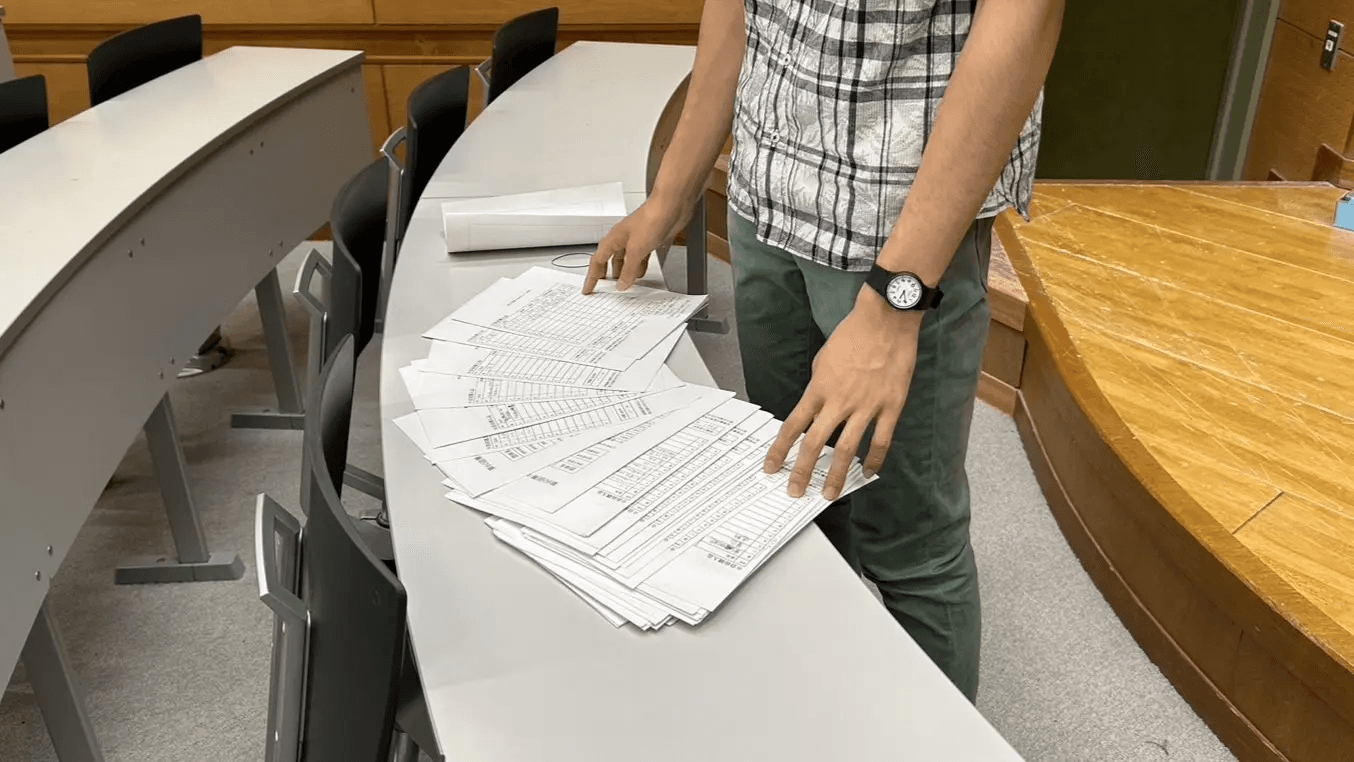 大量の予算申請書に頭を悩ませる会計パート長